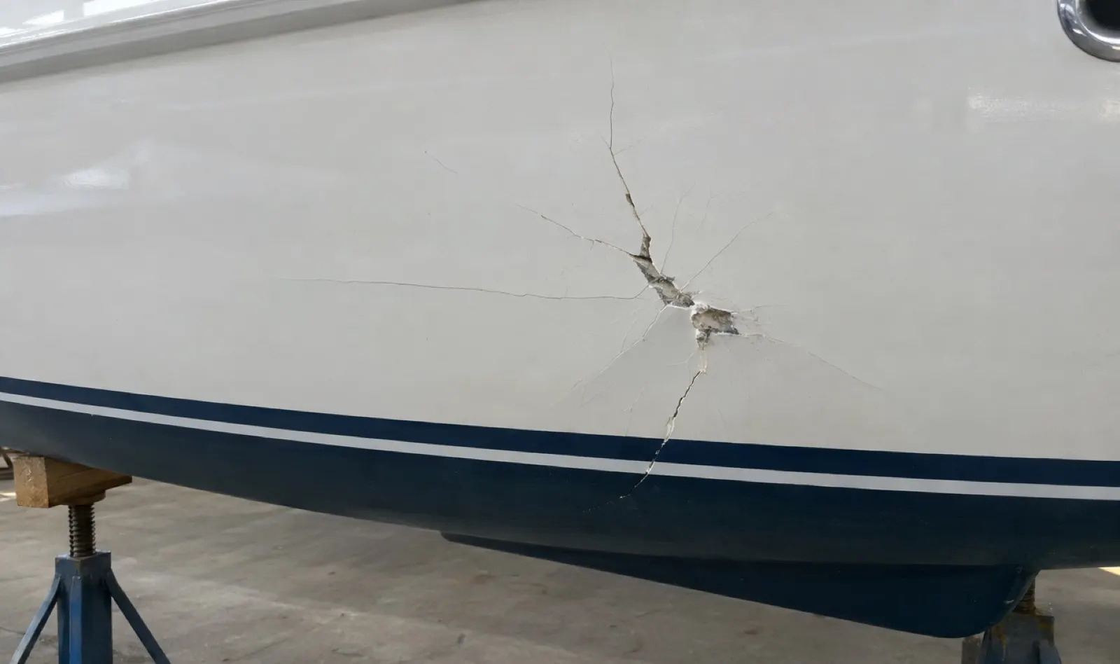 Impact crack with star-crazing on a white hull side